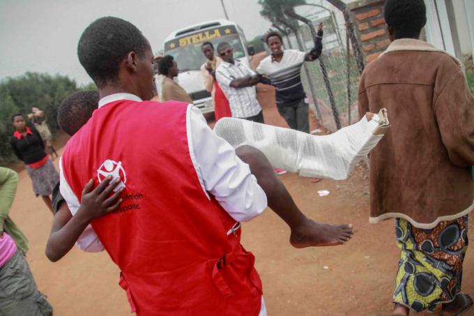 A boy with a broken leg is taken to hospital by Save the Children nurse