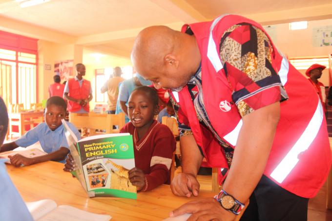 Philippe Adapoe, Country Director, SC-Rwanda interacting with refugee children in the Library