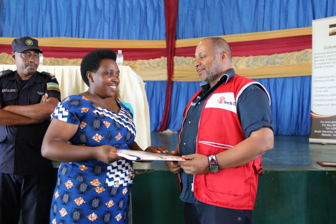 Philippe Adapoe Save the Children Rwanda Country Director handing over project documents to the Gicumbi Disctrict Official