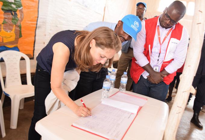 Princess Sarah signs the visitors' book after her visit to Mahama Refugee Camp.